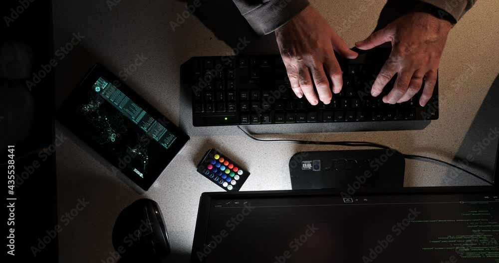 Poster hacker types as the overhead camera moves across their work area