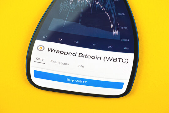 Buy Wrapped Bitcoin WBTC crypto currency, mobile phone app with button, concept of online trade, investment and coin exchange with smartphone, finance, office desk top view