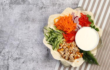 Shawarma Doner Kebab with sauce and flat bread on a square  plate on a dark background. Top view, flat lay