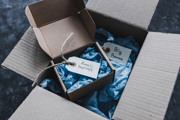 product tags with small business vs big brand texts inside of bigger and smaller delivery parcels,...