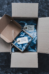 product tags with small business vs big brand texts inside of bigger and smaller delivery parcels,...