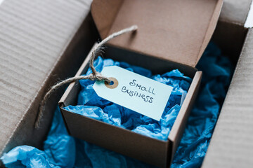 product tag with small business text inside ofsmaller delivery parcel inside of a bigger parcel,...