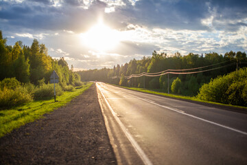 Obraz premium Country road with markings in the middle of the forest. 