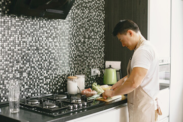 Asian man prepare dinner in a kitchen