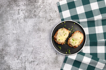 Chicken Roasted with cheese on bread on a round plate on a dark grey background. Top view, flat lay