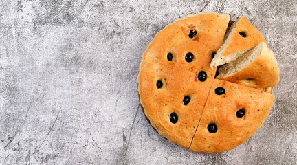 Traditional italian focaccia on a dark grey background. Top view, flat lay