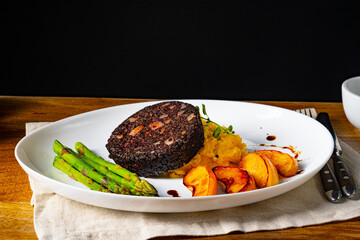 Black pudding with green asparagus and fried apple