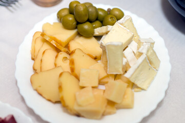 cheese plate with olives,mozzarella, gorgonzola on a white plate.Top view.