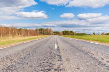 Fototapeta na wymiar Asphalt road field and forest sunny white cloud blue sky shot.