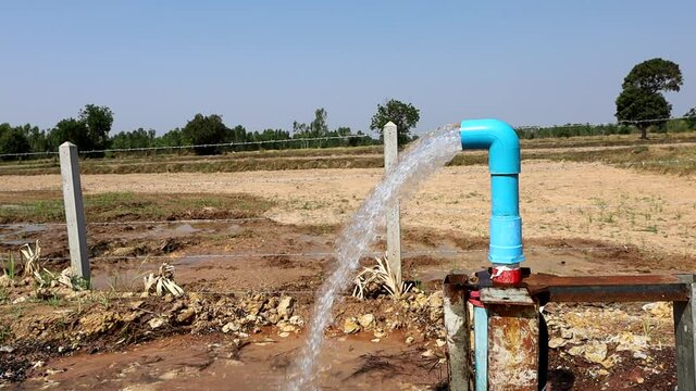 Water gushes from the PVC pipe. Silver groundwater flows out of plastic pipes with submersible pumps powered by solar panels or photovoltaics made from silicon.