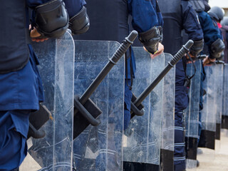 Riot police practice shields and baton