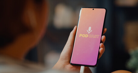 Young attractive Asia lady wear headphones using phone listen digital music podcast online channel...