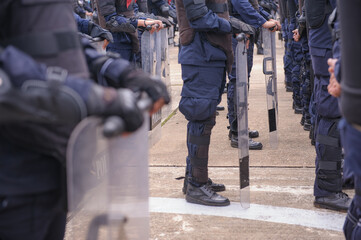 Riot police practice shields and baton
