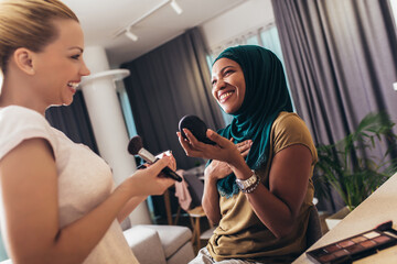 A make-up artist makes up a Muslim woman at home.