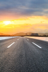 Asphalt road and beautiful seaside scenery at sunset.