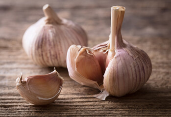 few pieces of garlic on wooden background