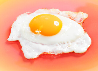 close-up view of sunny-side fried egg on orange plate