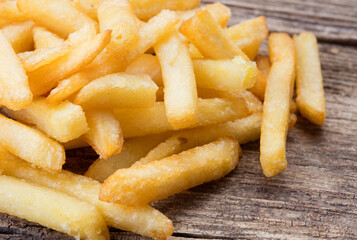 close-up view of heap of french fries on wooden background