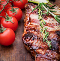 medium roasted porterhouse beef steak whith vegetables on wooden background