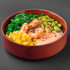 Hawaiian shrimp poke bowl with vegetables on grey background