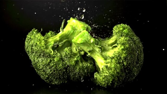 Super slow motion on broccoli drop water droplets. Filmed at 1000 fps.On a black background.