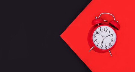 Red alarm clock on a red background with an arrow switching to a black background