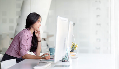 Obraz na płótnie Canvas Young asian beautiful woman working on computer with happiness in modern office.