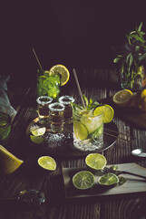 Dark photography with a vintage look of a cold drink, a glass of mojito with mint leaf, ice, lemon...