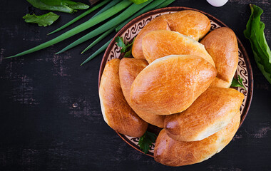 Traditional Ukrainian pies with eggs, green onion, sorrel on dark  background. Russian piroshki, homemade baked patties. Top view, above, copy space © timolina