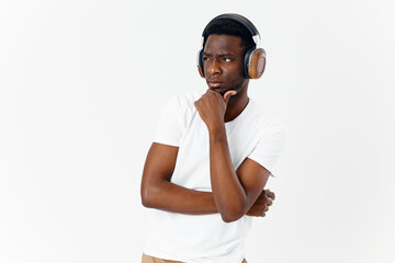 man of african appearance in headphones listening to music white t-shirt