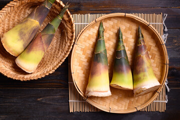 Fresh bamboo shoot in a basket on wooden background, Edible vegetable in Asian cuisine