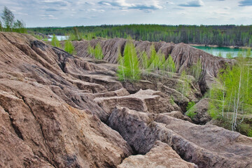 Beautiful natural relief landscape with green birches on the quarry hills in spring