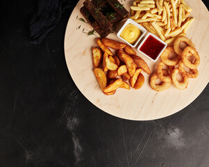 tackler with snacks on black textured background top view