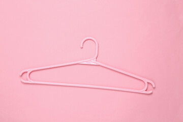 Plastic hanger on pink background. Fashion layout. Flat lay. Top view