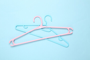Plastic hangers on a blue background. Fashion layout. Flat lay. Top view