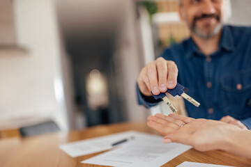 Adult man giving blue car keys to someone, buyer.
