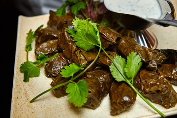 Dolma with spicy sour cream sauce. Close-up, selective focus