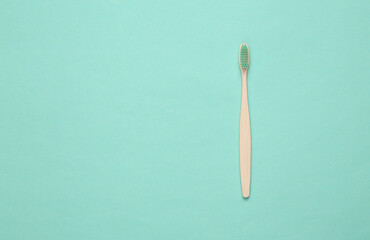 Eco-friendly bamboo toothbrush on blue background. Top view. Copy space