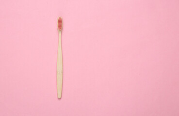 Eco-friendly bamboo toothbrush on pink background. Top view. Copy space