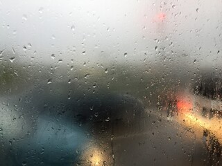 raindrops on a window with a blurred background of cars. fogged glass of the car.
