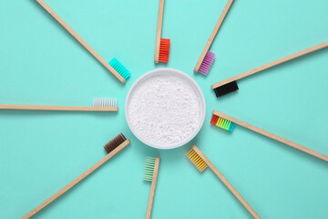 Eco-friendly bamboo toothbrushes and tooth-powder on blue background. Top view.