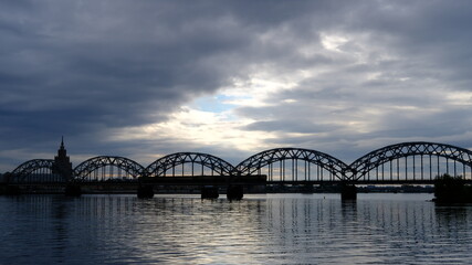 Fototapeta na wymiar Spring, dawn over the Daugava on the background of the railway bridge
