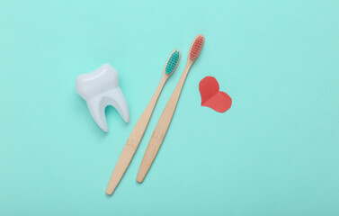 Eco-friendly bamboo, heart and toothbrush and tooth on pink background. Love, Dental care concept..Top view.