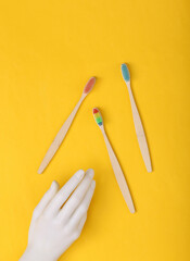 Hand and Toothbrushes on yellow background.