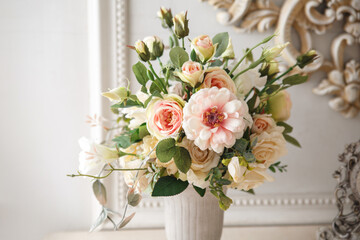 Delicate decorative bouquet of roses in a vase on the table.