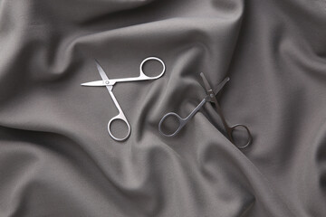 Manicure scissors on a gray silk background. Beauty concept