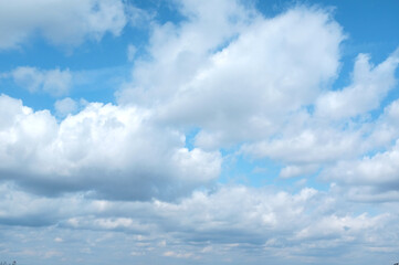 Naklejka na ściany i meble Big white clouds on a blue sky in clear weather