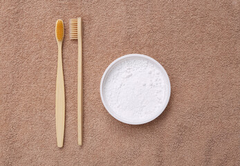 Eco-friendly bamboo toothbrush and tooth-powder on towel. Top view. Flat lay