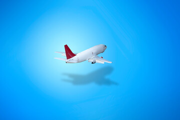 Fototapeta na wymiar White Airplane flying on the blue isolated background with shadow