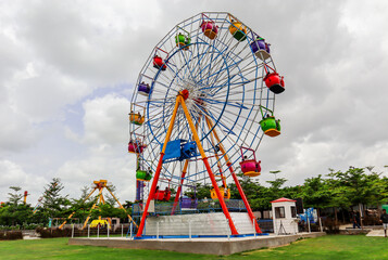 A multicolor Ferris wheel in a public/water park. Side view. Telangana Hyderabad Tourism.